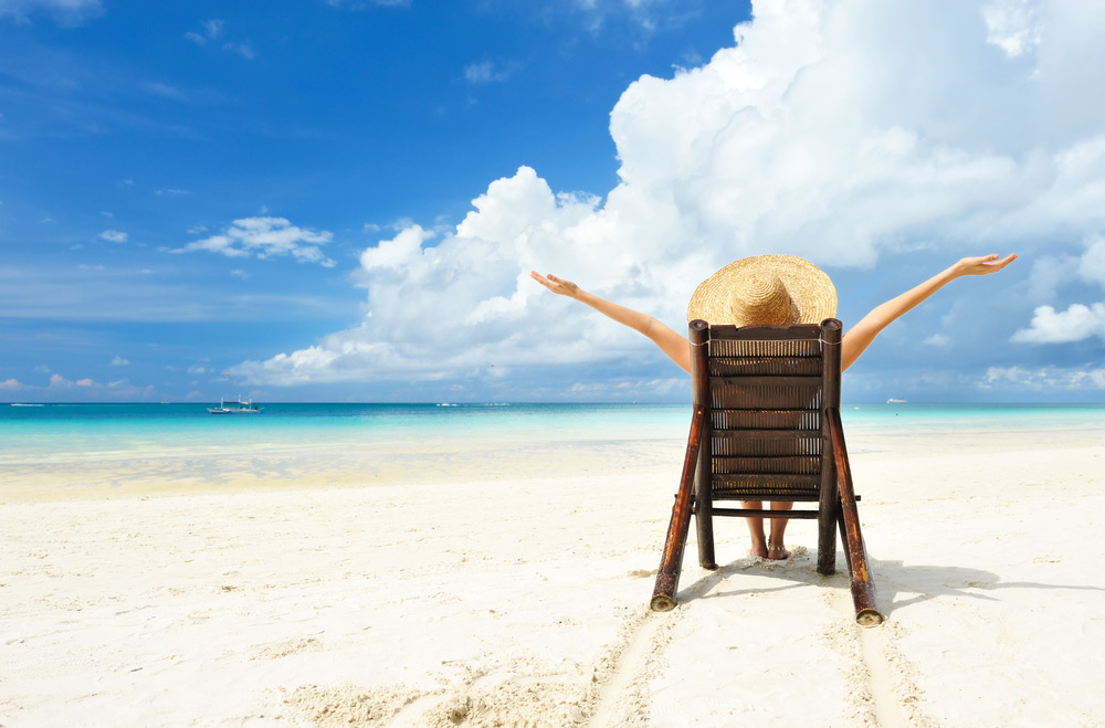 woman sitting on the beach in a chair